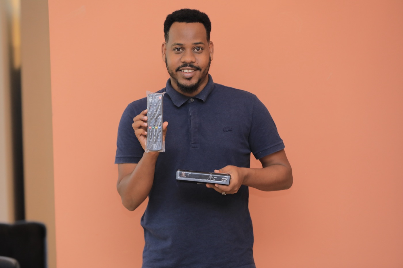An Astaan presenter holding a phone and an Astaan receiver